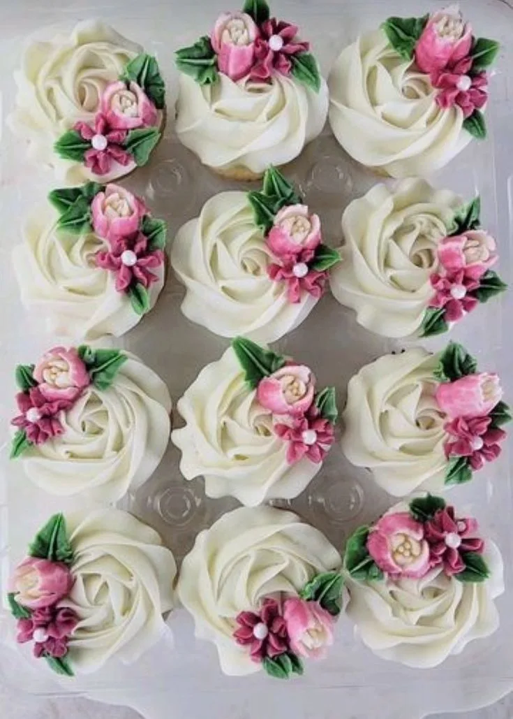 Twelve cupcakes are arranged in a grid within a clear plastic tray.